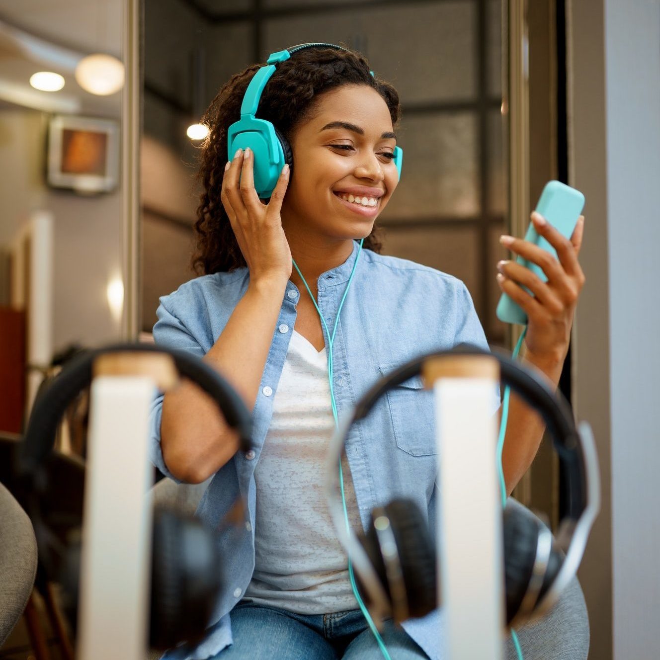 woman listening to music in headphones store e1648532271635